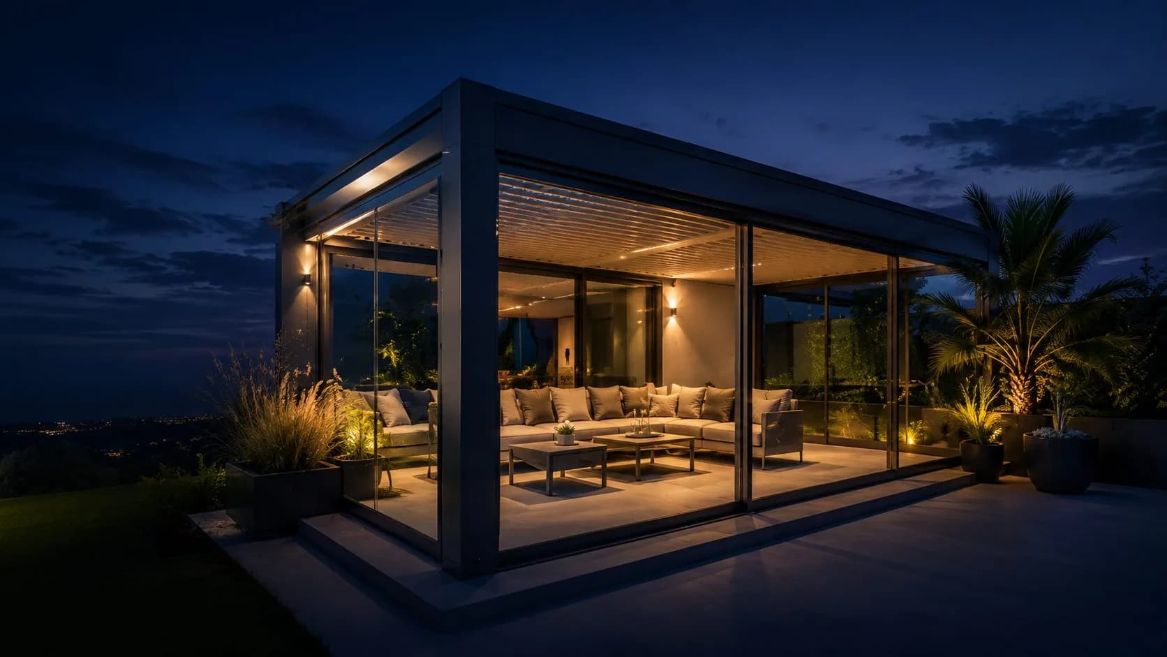Pergola bioclimatique vitrée et éclairée de nuit, ouverte sur une terrasse
